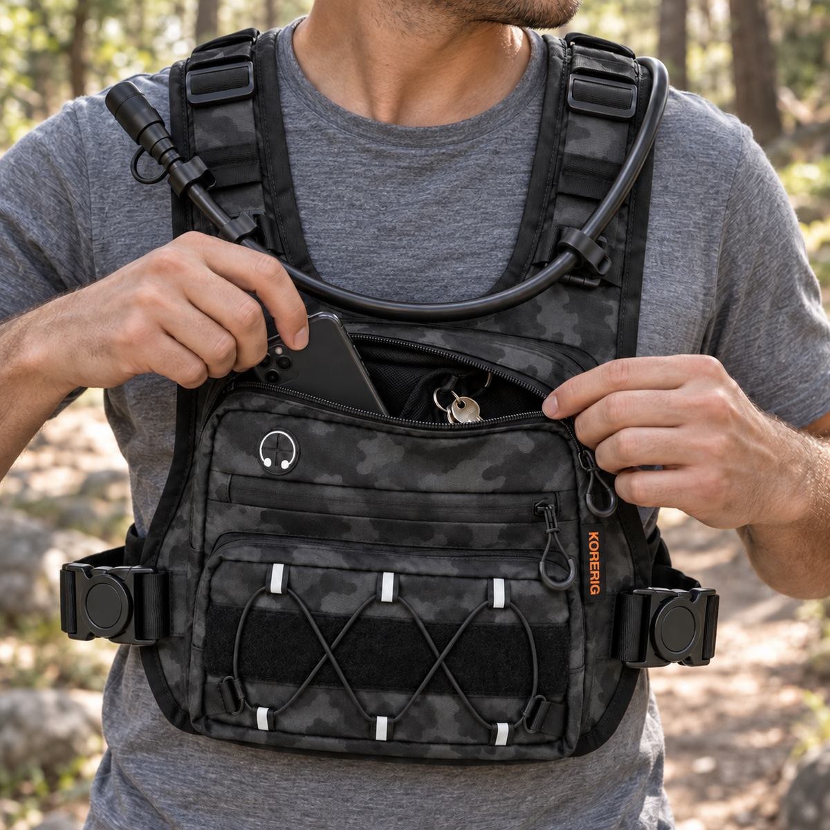 Phone and keys inside the open front pouch of a KORERIG vest in Black Camo